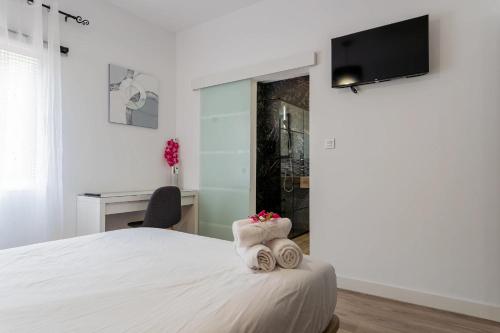 a bedroom with a bed and a desk and a tv at Casa Mario Suites in Santa Cruz de Tenerife