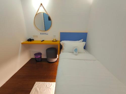 a small bedroom with a bed with a mirror at TREASURE BOX At Heritage Georgetown in George Town