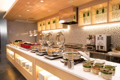 a kitchen with many pots and pans on a counter at Urban Hotel Kyoto Nijo Premium in Kyoto