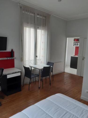 une chambre avec une table, des chaises et un lit dans l'établissement Studio proche gare - 4, au Mans