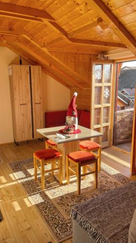 a wooden room with a table and some chairs and a window at Eko Apartmani in Bački Petrovac