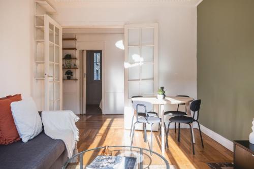 un salon avec une table, des chaises et un canapé dans l'établissement Logement Haut de Gamme à Grenelle, à Paris