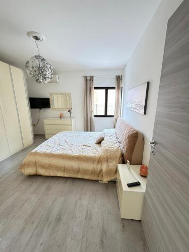 a white bedroom with a bed and a table at Favoloso CON TERRAZZO in Frosinone