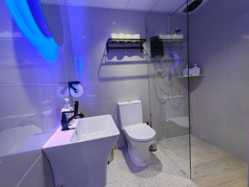 a bathroom with a toilet and a shower and a sink at TREASURE BOX At Heritage Georgetown in George Town