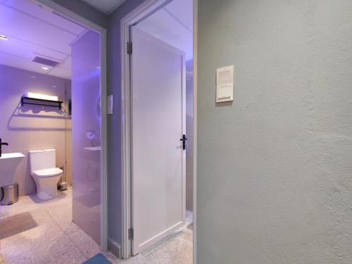 a bathroom with a toilet and a glass door at TREASURE BOX At Heritage Georgetown in George Town