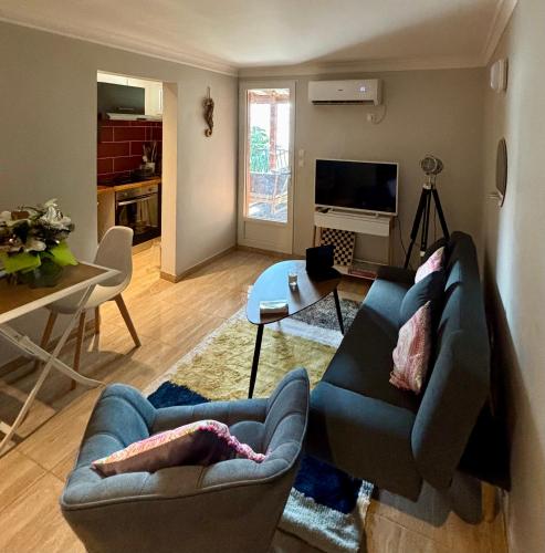 a living room with a blue couch and a table at Cozy apartment with a relaxing terrace, 10 min from beaches and restaurants in Marigot