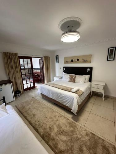 a large bedroom with two beds and a rug at Caribe Accommodation and Conferences in Pietermaritzburg
