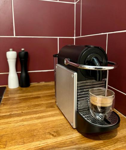 a coffee maker on a counter with a cup of coffee at Cozy apartment with a relaxing terrace, 10 min from beaches and restaurants in Marigot