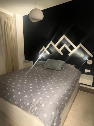 een bed in een slaapkamer met een zwarte muur bij Vučko Delux in Bjelašnica