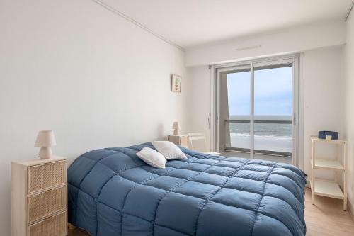 - une chambre avec un lit bleu et une vue sur l'océan dans l'établissement Magnifique vue mer, à La Baule