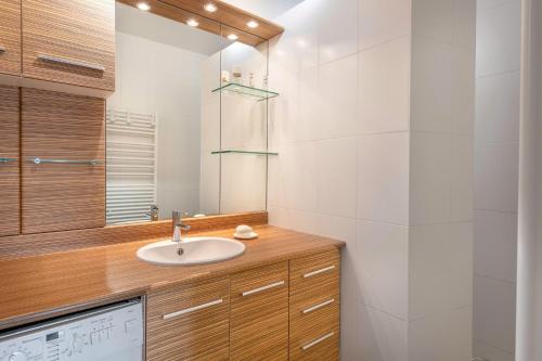 une salle de bain avec un lavabo et un miroir dans l'établissement Magnifique vue mer, à La Baule