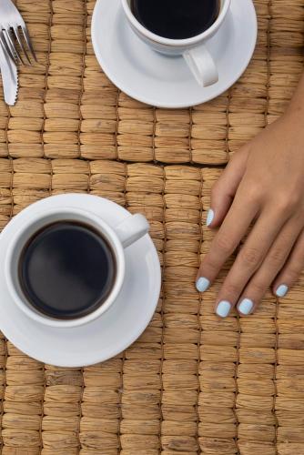 a woman with blue nails and a cup of coffee at REFUGIO LA ROCA in Los Santos