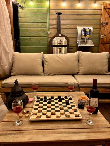 a chess board on a table with two glasses of wine at Cozy apartment with a relaxing terrace, 10 min from beaches and restaurants in Marigot