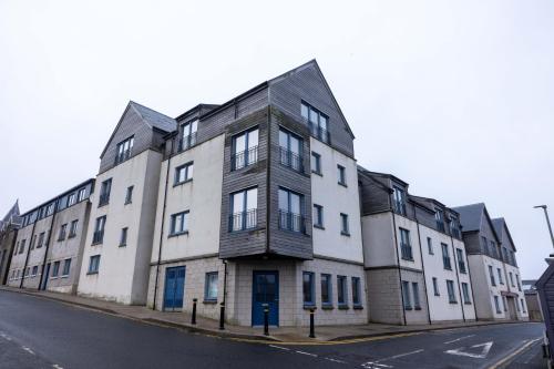 a large white building on a street corner at Lerwick Penthouse Apartment in Lerwick