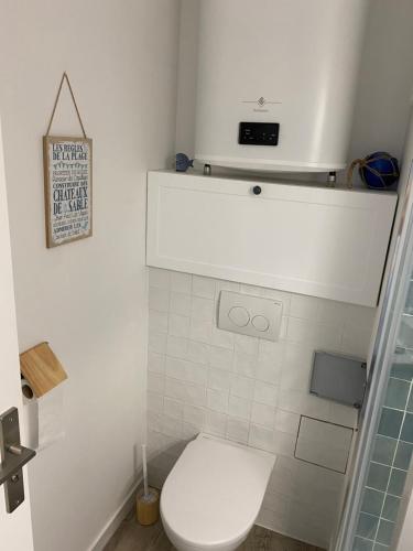 une salle de bain blanche avec toilettes et douche dans l'établissement Aux pieds des plages, du port, de la piste cyclable et des commerces de proximité, un studio au dernier étage avec une vue panoramique sur le Bassin d'Arcachon, entièrement rénové, dans une résidence avec piscine, à Arcachon