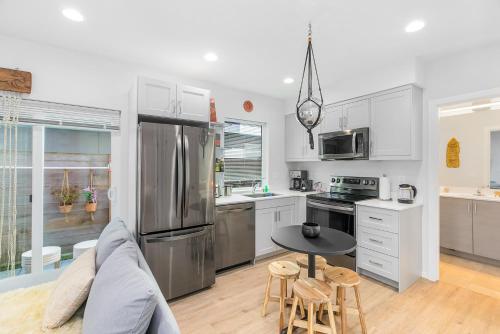 a kitchen with a stainless steel refrigerator and a table at The Sweetest Suite - 91 Walkscore! in Seattle