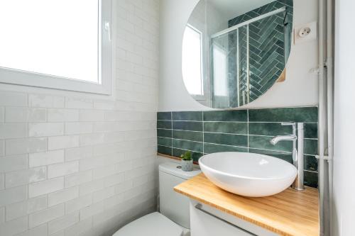 une salle de bain avec un lavabo et un miroir dans l'établissement Appartement Cozy à Paris, à Paris