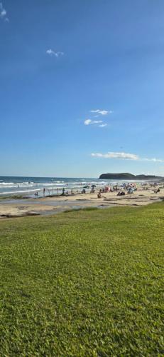 a beach with a group of people in the ocean at Hotel Ficare Torres in Torres