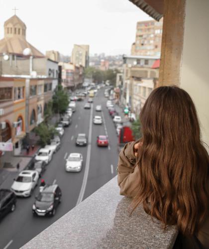 a woman looking out of a window at a city street at RG Boutique Hotel in Yerevan