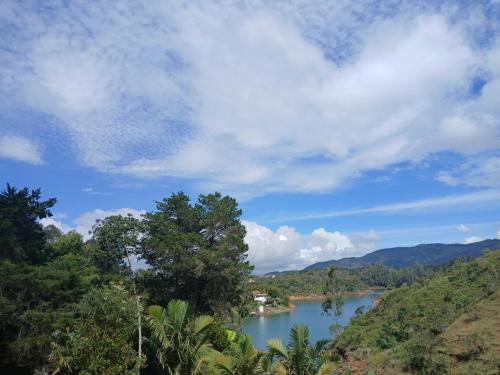 a view of a river from a hill with trees at Hotel Bahia Del Faro in Guatapé