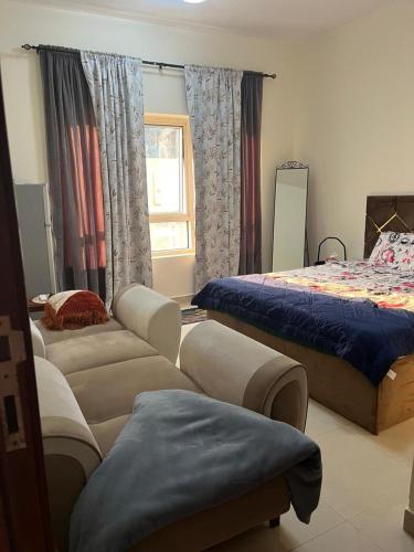 a living room with two beds and a window at Pure zamzam Guest House At Al nahda Sharjah Dubai Border-FAMILY ONLY in Sharjah