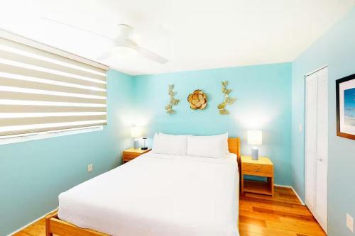 a bedroom with a bed and a blue wall at Cat Island Suite - Sunrise Suites in Key West
