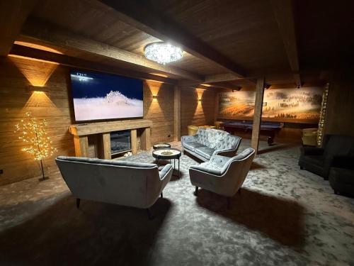 a large living room with a couch and a tv at Hotel Lesana in Špindlerův Mlýn