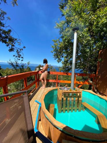 a woman in a bikini sitting on a deck at Cabaña entre mares Huelmo in Puerto Montt