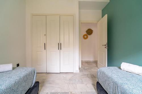 a bedroom with two beds and a closet with a door at AeroSerenity in Nouaceur