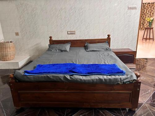 a bed with a blue blanket on it in a room at Murdeshwar Coastal Comfort in Māvalli