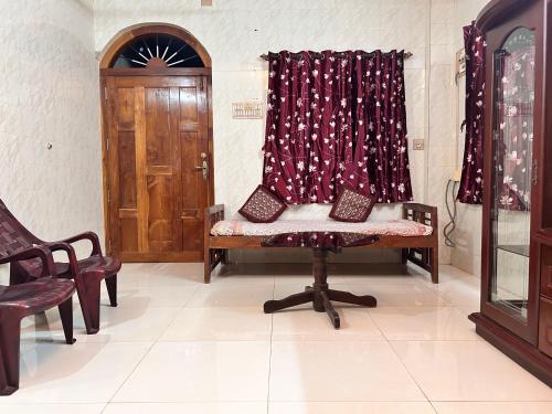 a room with a bench and a curtain and a door at Murdeshwar Coastal Comfort in Māvalli