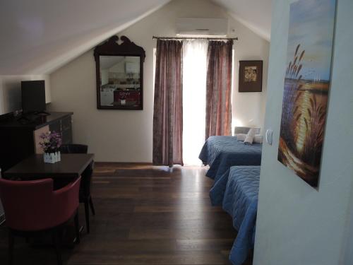 a bedroom with a bed and a table and a window at Apartments 43 in Krnjača