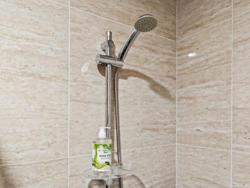 una ducha con cabezal de ducha en un baño en Newly South Gate Studio Apt with Pool, Gym Netflix by 2ndHome, en Yakarta
