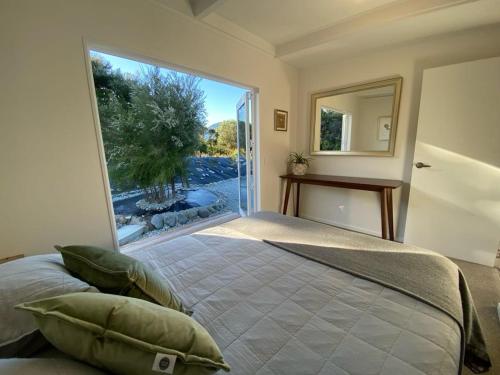 a bedroom with a bed and a large window at Collingwood Cottage in Collingwood