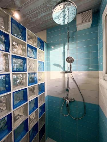 une salle de bain avec douche aux carreaux bleus dans l'établissement Appartement familial proche des plages, à Mimizan-Plage