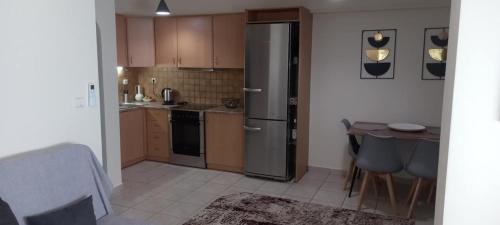 a kitchen with a stainless steel refrigerator and a table at La casa bella di Chalkida 2 in Chalkida