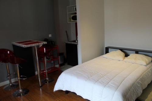 une chambre avec un lit blanc et une chaise rouge dans l'établissement Magnifique appartement entre centre ville et gare - 5, au Mans