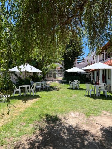 a group of tables and umbrellas in a yard at Sauce Viejo in Mina Clavero