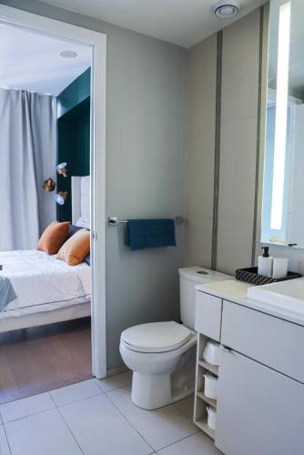 a white bathroom with a toilet and a bed at Stunning suite in downtown perfect for businesses trips and small families in Toronto