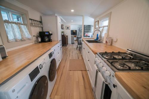 a kitchen with a stove and a washer and dryer at Hadley Hideaway Cottage in Hadley