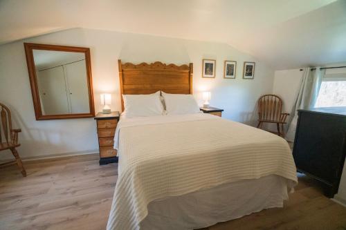 a bedroom with a large bed and a mirror at Hadley Hideaway Cottage in Hadley