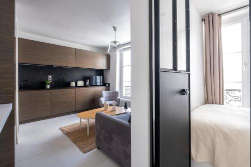 Cette chambre comprend un lit, un canapé et une table. dans l'établissement Havre de Luxe au Pied de Montmartre, à Paris