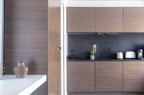 une cuisine avec des placards en bois et un vase sur un comptoir dans l'établissement Havre de Luxe au Pied de Montmartre, à Paris