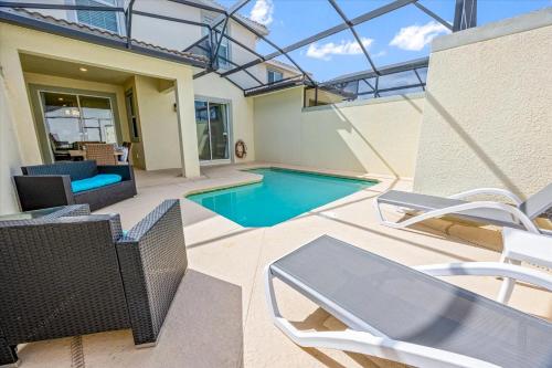 a house with a swimming pool and a patio with chairs at La Casista in Orlando