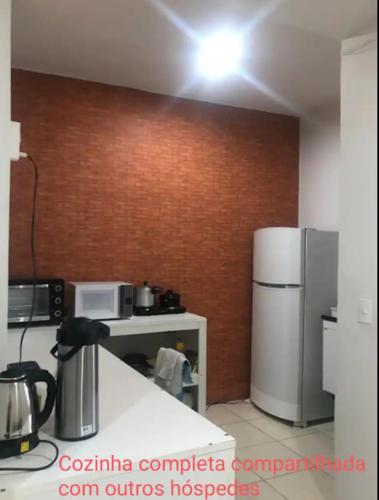 a kitchen with a white counter and a refrigerator at Suíte 101 - Pousada no Centro do Rio in Rio de Janeiro