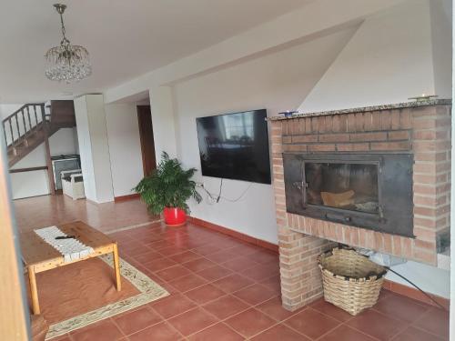 a living room with a brick fireplace and a tv at El Rancho Busto - Luarca in Busto