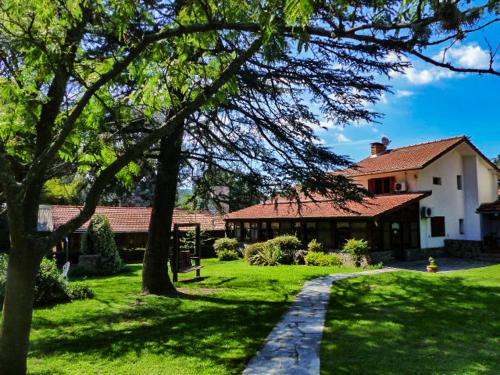 a house with a pathway in front of a yard at Hostal La Merced in Villa General Belgrano