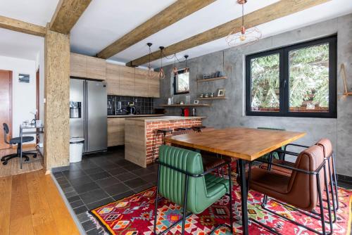 a kitchen with a wooden table and green chairs at Kežman Mountain Houses in Kopaonik