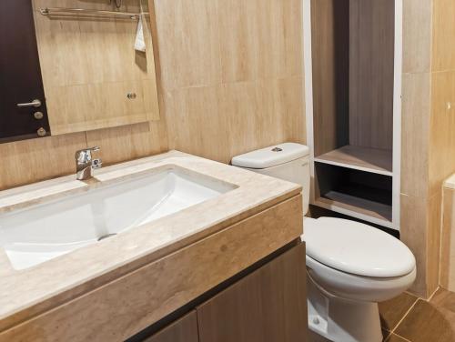 a bathroom with a tub and a toilet and a sink at Newly 1BR Apt Cikarang with Pool, Gym & Wi-Fi by 2ndHome in Leuweungmalang