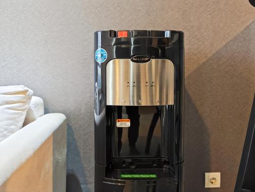 a black coffee maker sitting on a table at Newly 1BR Apt Cikarang with Pool, Gym & Wi-Fi by 2ndHome in Leuweungmalang